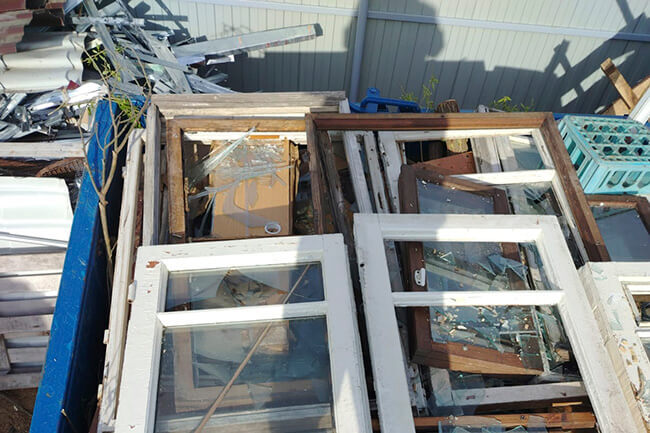 Старые окна и двери, выброшенные на мусор