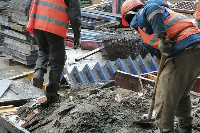 Рабочие разгребают завалы промышленного мусора